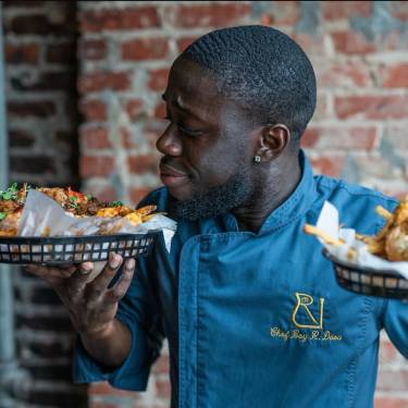 Server holding food at Miss Toya's Creole House